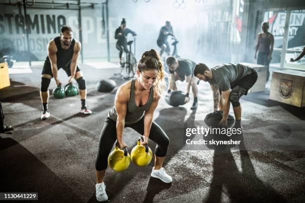 large group of athletes exercising strength of cross training in a gym. - cross training stock pictures, royalty-free photos & images
