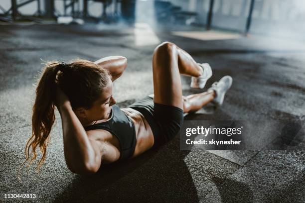 sportliche frau sit-ups in einem fitnessstudio trainieren. - rumpfbeuge stock-fotos und bilder