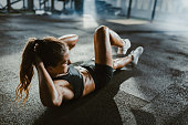 Athletic woman exercising sit-ups in a health club.
