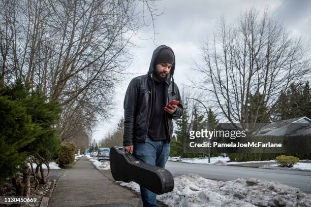 camminare con la chitarra su snowy street - custodia per chitarra foto e immagini stock