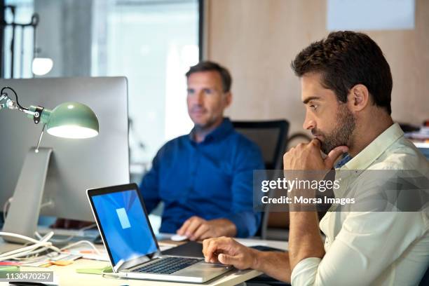 uomo d'affari premuroso che usa laptop a tavola - angle poise lamp foto e immagini stock