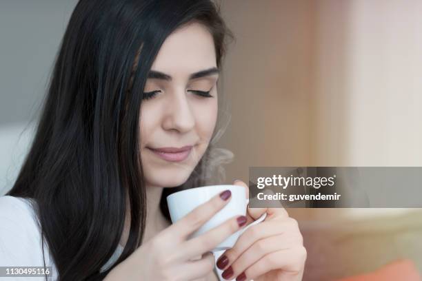 beautiful young women drinking hot coffe - enjoying coffee cafe morning light stock pictures, royalty-free photos & images