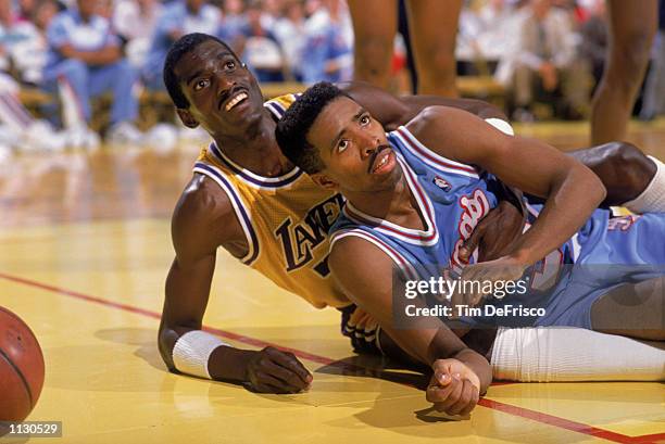 Kenny Smith of the Sacramento Kings falls out of bounds with Michael Cooper of the Los Angeles Lakers during a NBA game at Arco Arena in Sacramento,...