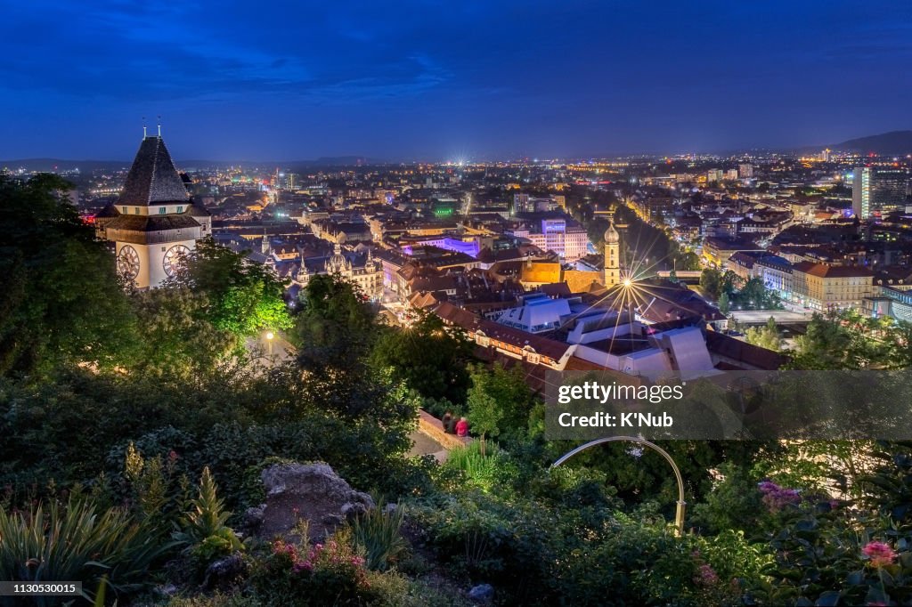 Beautiful view of clock tower, landmark, on high mountain after sunset time in center of Graz city, Austria, Europe