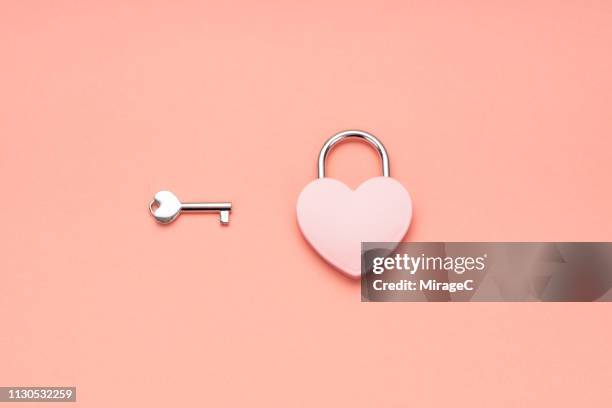 pink heart shape padlock and key - cerrar con llave fotografías e imágenes de stock