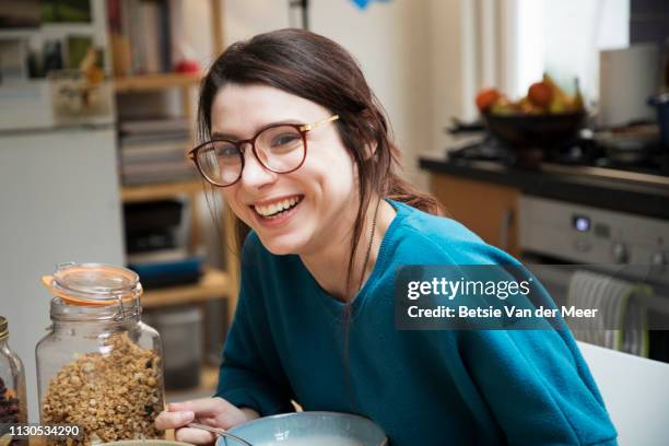 woman laughing at breakfast table in kitchen. - breakfast lifestyle female stock-fotos und bilder