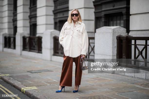 Sonia Lyson is seen wearing Manolo Blahnik heels, wide leg pants, shearling shirt Topshop, see through bag Topshop, Zara sunglasses during London...