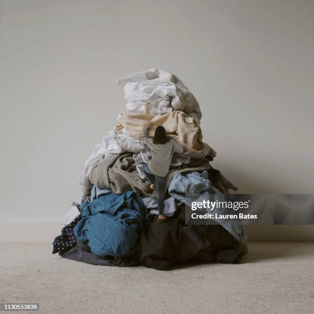 woman climbing laundry mountain - traje completo imagens e fotografias de stock