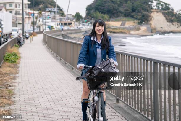 高校の女の子自転車で家に帰る - 若い カワイイ 女の子 日本人 ストックフォトと画像