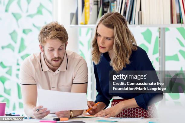 business people reviewing paperwork in meeting in modern office - man eye cream stock pictures, royalty-free photos & images