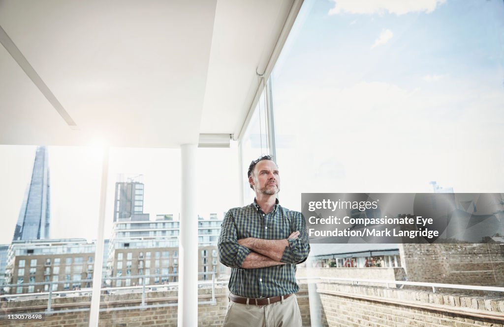 Businessman standing by window in modern office