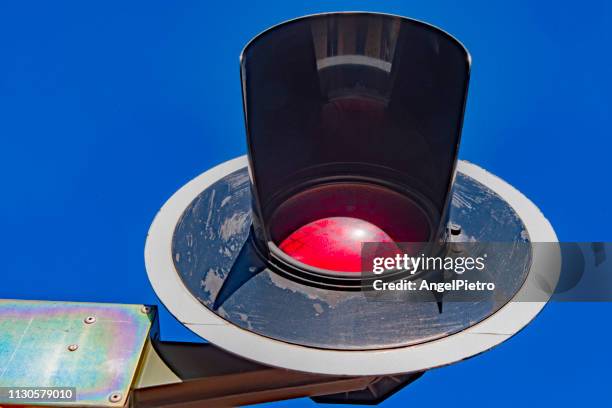 a single red light in a railway crossing - personas ciudad stock pictures, royalty-free photos & images