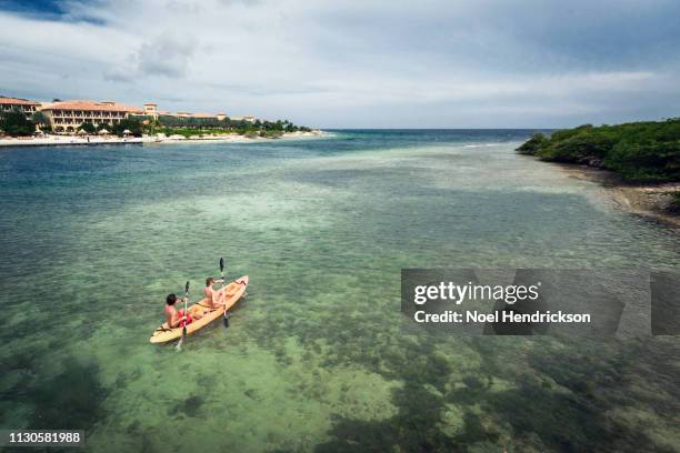 sunlit couple kayaking in the bay - willemstad stockfoto's en -beelden