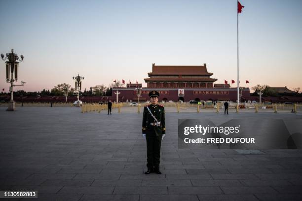 Paramilitary policeman stands during the daily flag-raising ceremony in Tiananmen Square before the closing session of the National People's Congress...