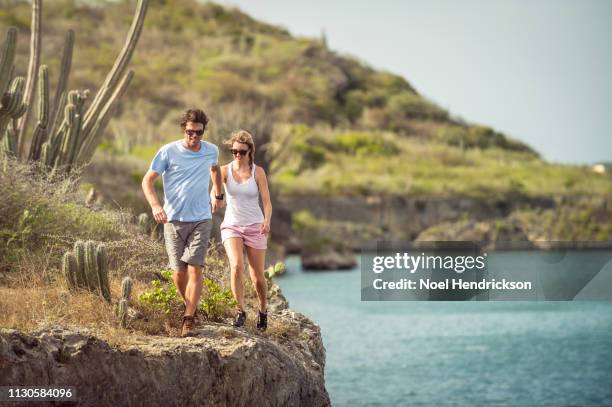 man and woman hiking along a seaside trail in curaçao - willemstad stockfoto's en -beelden