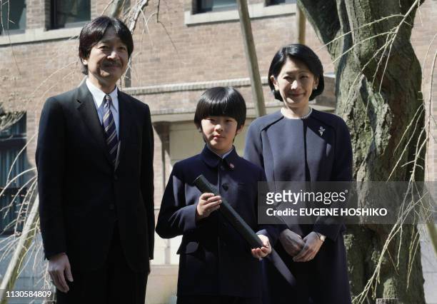 Japan's Prince Hisahito , accompanied by his parents Prince Akishino and Princess Kiko pose for the media after his graduation ceremony of a primary...