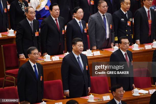 Chinese President Xi Jinping sings the national anthem with Chinese Premier Li Keqiang and Politburo Standing Committee member Wang Yang during the...