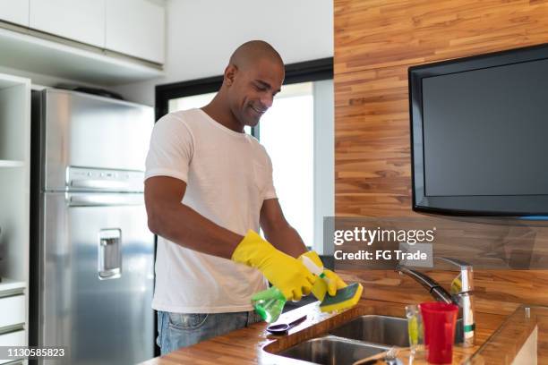 afro man washing dishes at home - afro man washing stock pictures, royalty-free photos & images