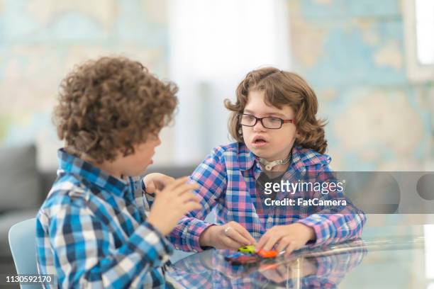twee (2) jonge jongens met elkaar praten - disabilitycollection stockfoto's en -beelden