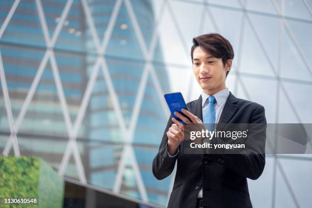 asian businessman using his smartphone - yongyuan hongkong stock pictures, royalty-free photos & images