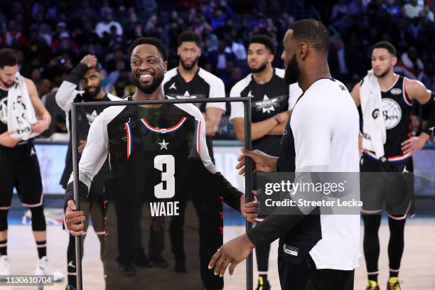 Dwyane Wade of Team LeBron receives commemorative All-Star jersey from LeBron James after the NBA All-Star game as part of the 2019 NBA All-Star...