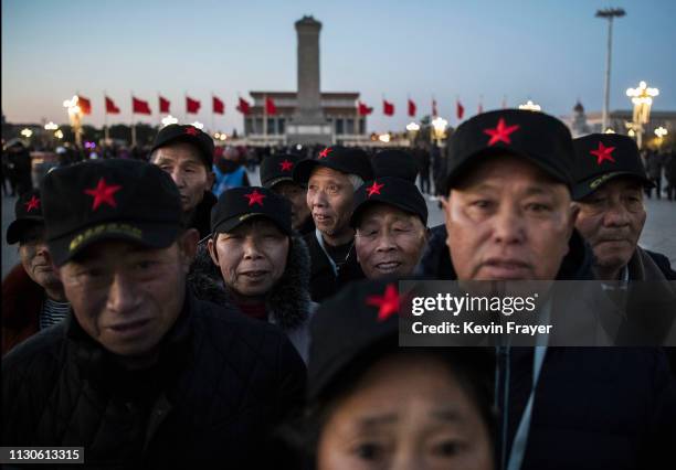 Chinese visitors wearing hats with a red star wait in Tiananmen Square before the daily flag raising ceremony prior to the closing meeting of the...