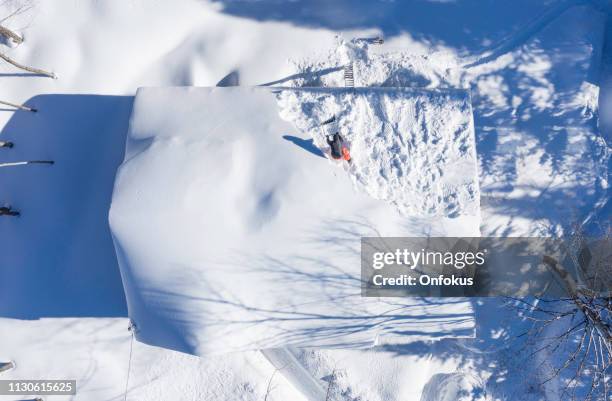 aerial view of a man shoveling snow from a house roof top after snowstorm - collapsing house stock pictures, royalty-free photos & images