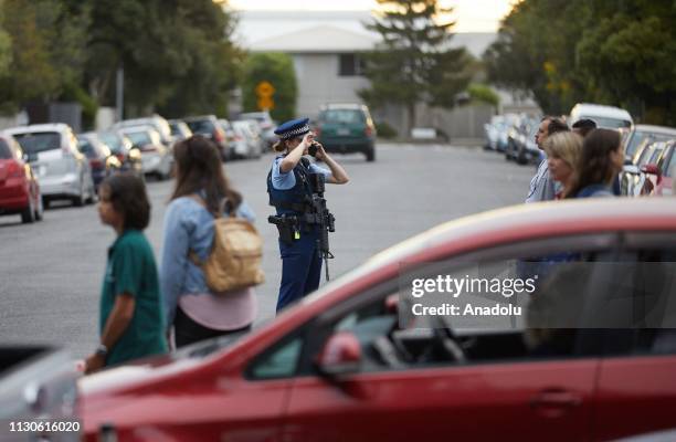 Residents wait around the scene as they worry about their relatives after gunmen attacked the two mosques and fired multiple times during Friday...