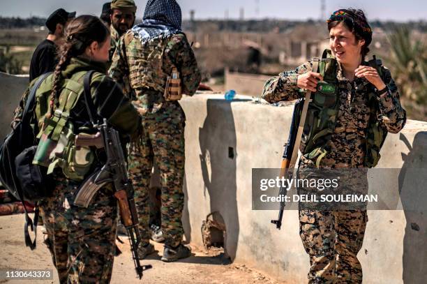 Mixed members of the Kurdish-led Syrian Democratic Forces are pictured on a rooftop in the village of Baghouz, near Syria's border with Iraq, in the...