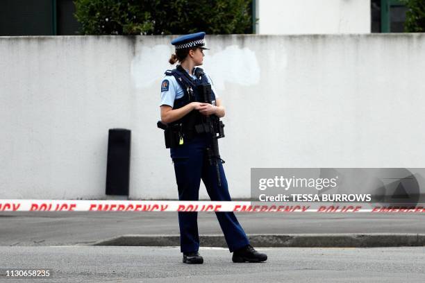 Police officer secures the area in front of the Masjid al Noor mosque after a shooting incident in Christchurch on March 15, 2019. - Attacks on two...