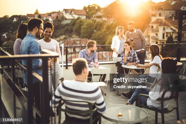 grote groep van gelukkige zakenmensen communiceren op een balkon na het werk. - coffee break party stockfoto's en -beelden