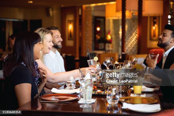 gruppe von multiethnischen arab-freunden mittagessen in einem restaurant in dubai - arabic food stock-fotos und bilder