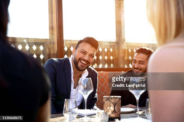 gruppo di amici arabi multietnici pranzano in un ristorante a dubai - cultura araba foto e immagini stock