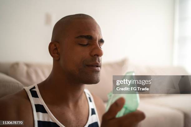 afro latin man holds a mask steam inhaler - inhalation stock pictures, royalty-free photos & images