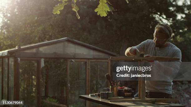 diy in the garden. renovating wooden table - masculinity stock pictures, royalty-free photos & images