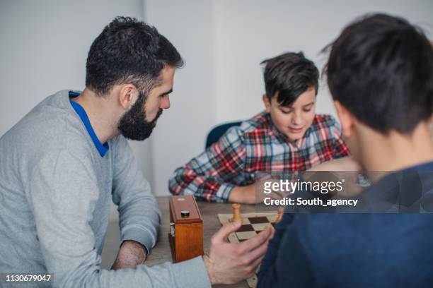 two young boys and chess teacher playing chess - chess timer stock pictures, royalty-free photos & images