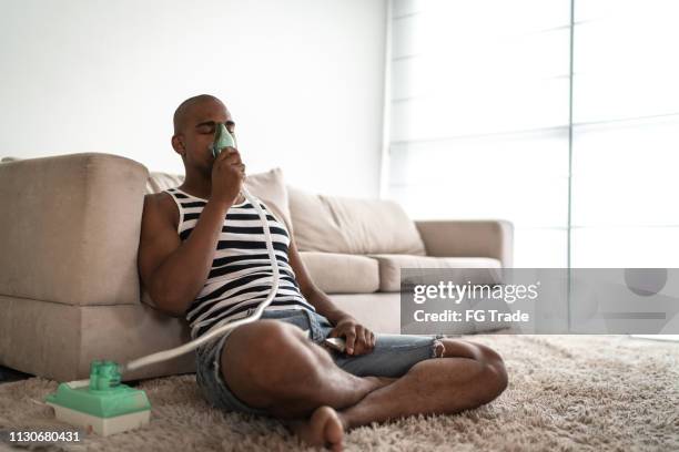 hombre afro tiene un inhalador de vapor de la máscara - nebulizador fotografías e imágenes de stock