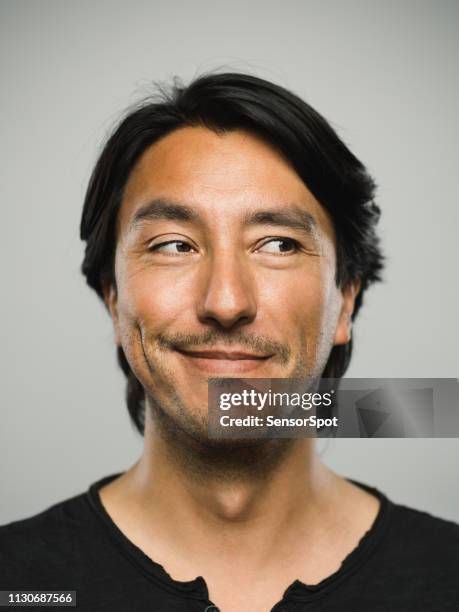portrait d’un homme réel hispanique avec expression heureuse à la recherche sur le côté - sourire narquois photos et images de collection