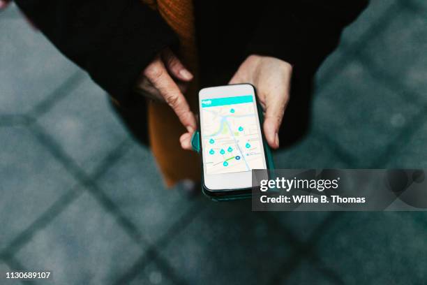 aerial view on woman using car sharing app - touch map stock-fotos und bilder