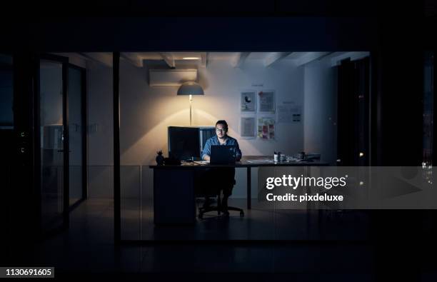 late nights don't phase him one bit - working overtime imagens e fotografias de stock