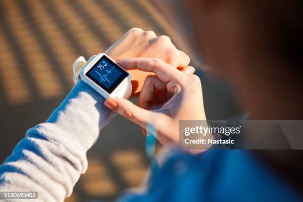 vérification de sa fréquence cardiaque sur une montre intelligente - montre connectée photos et images de collection