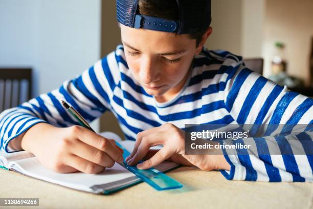 teenage boy doing homework at living room - ruler desk stock pictures, royalty-free photos & images