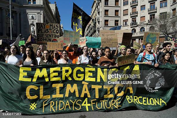 Students demonstrate behind a banner reading "Climate emergency" during the "Fridays For Future" movement on a global day of student protests aiming...