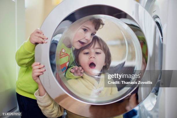 kids playing in front of a washing machine - clean clothes stock pictures, royalty-free photos & images