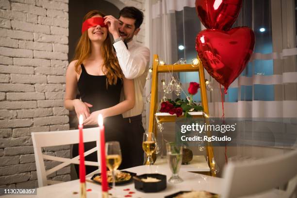 uomo che si toglie la benda della ragazza - valentines day dinner foto e immagini stock