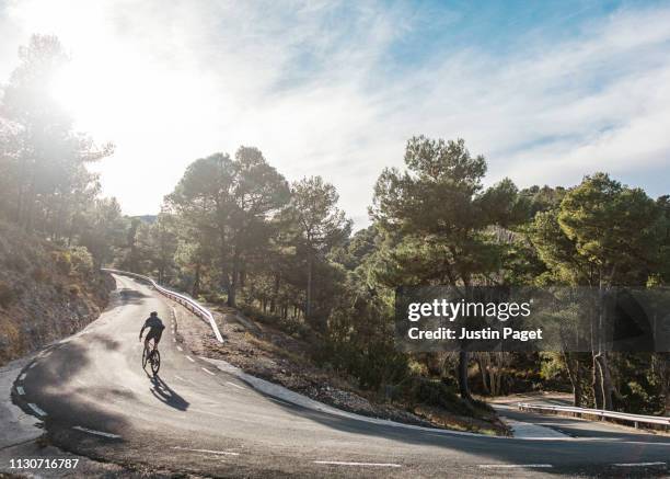 cyclist on steep hairpin - road cycling stock pictures, royalty-free photos & images