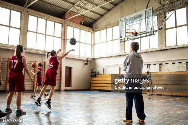 female coach watching teenage girls practicing free throws - girl in gym stock pictures, royalty-free photos & images