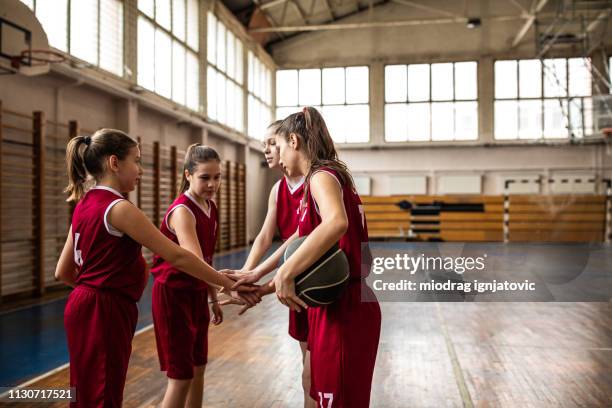 basketballspieler stapeln hände - basketball uniform stock-fotos und bilder