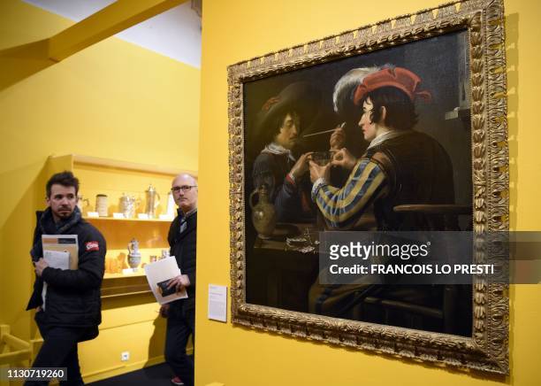 Visitors walk past the painting 'The Card Players' by Flemish painter Theodore Rombouts, during the preview of the exhibition 'A boire! Quand la...