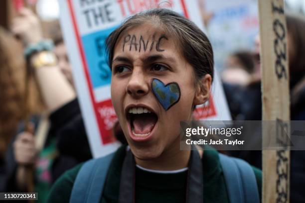 Girl wears face paint as schoolchildren take part in a student climate protest on March 15, 2019 in London, England. Thousands of pupils from...